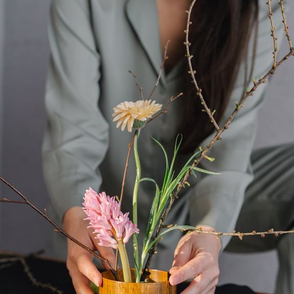 Person meditating in a bright, leafy room.